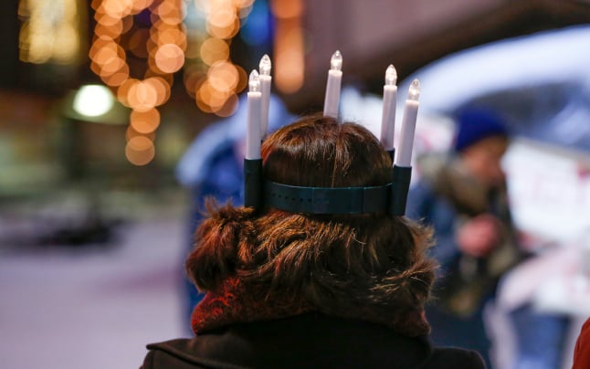 a person wearing electric Lucia candles in their hair