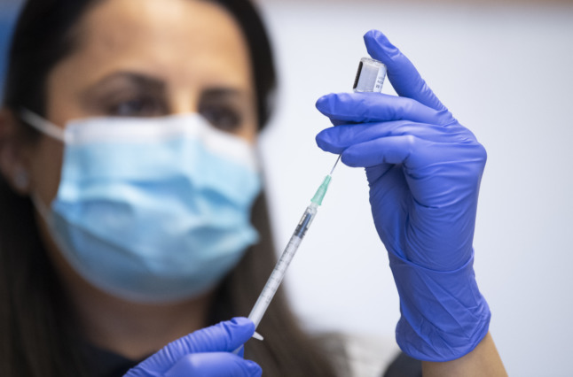 a nurse prepares a covid-19 vaccine